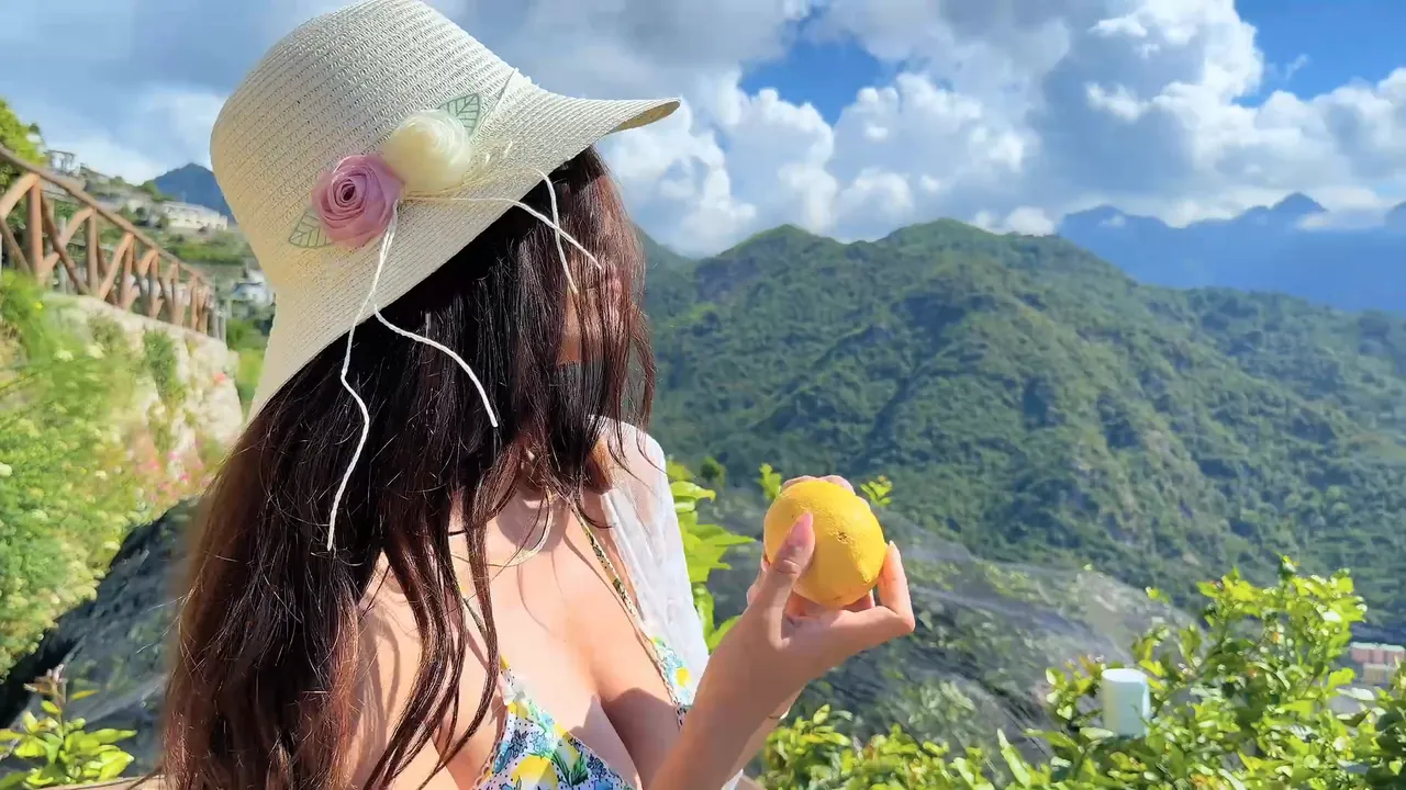 Un limone colto in giardino con la costa sullo sfondo